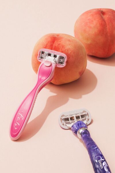 Pink razor and peaches representing intimate grooming and women's self-care